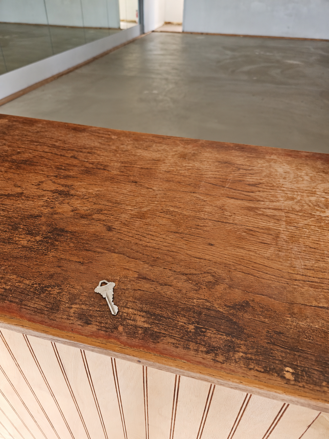 The key to Solecito Play Cafe resting on the wooden counter of the empty space